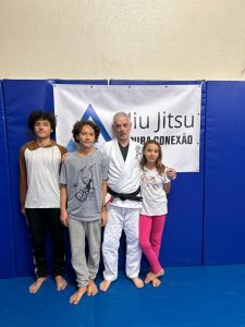 Foto de Carlos Caldeira com três crianças praticantes de Jiu Jitsu